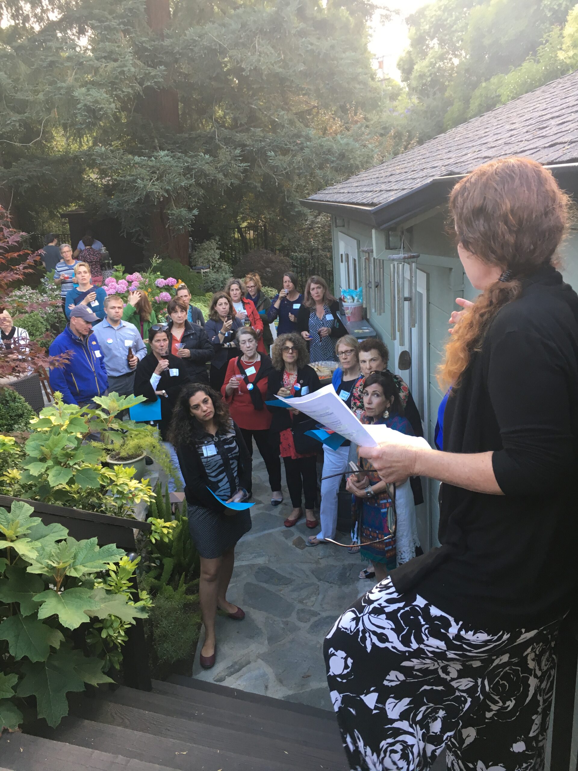 Group of more than 20 volunteers in California listen to a team leader give canvassing instructions